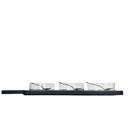 Three glass bowls on a black shelf against a white background