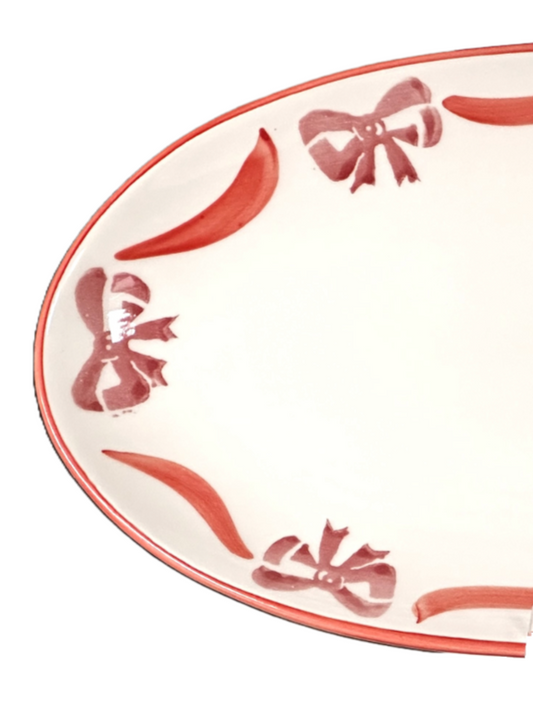 Oval platter with decorative red bows on a white background