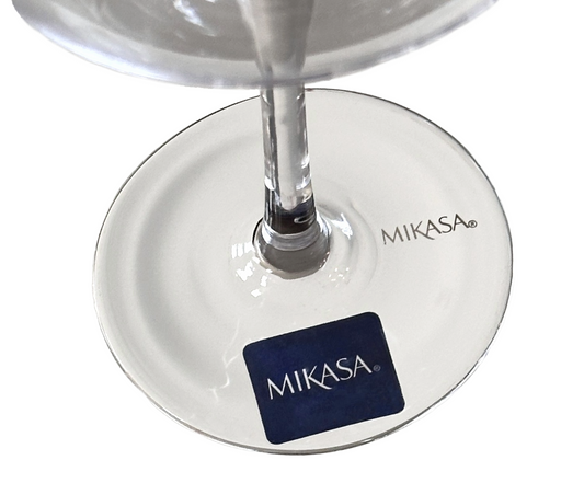 Mikasa glass with a clear liquid being poured into it on a white background