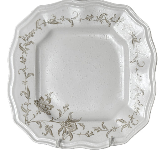 Decorative white plate with floral patterns on a white background