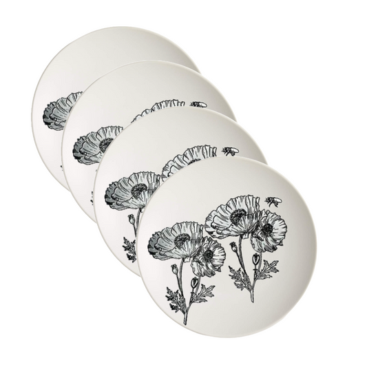 Four white ceramic plates with black floral designs