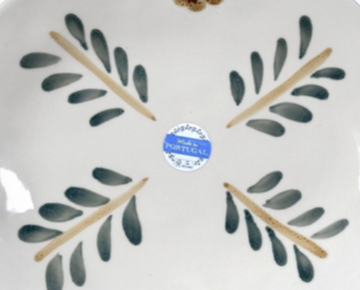 Ceramic plate with leaf design and 'Made in Portugal' label on a white background